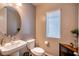 Powder room showcases a vessel sink, round mirror, and neutral tones at 541 Tokopah Falls St, Las Vegas, NV 89138