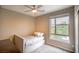 Neutral-toned bedroom with cozy bed, ceiling fan, and natural light at 541 Tokopah Falls St, Las Vegas, NV 89138