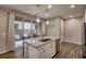 Well-appointed kitchen island with a stainless sink, seating, and modern lighting, opening to the patio at 541 Tokopah Falls St, Las Vegas, NV 89138