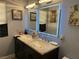 Bathroom with a double sink vanity with marble countertop, dual mirrors, and decorative tile flooring at 6248 Sapporo Cir, Las Vegas, NV 89110