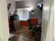Bedroom-converted office with wooden laminate floors, window blinds, and office furniture at 6248 Sapporo Cir, Las Vegas, NV 89110