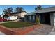 Inviting home exterior showcasing a pristine artificial turf lawn and brick-lined driveway at 6421 Doby Peak Dr, Las Vegas, NV 89108