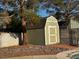 Well maintained shed in backyard surrounded by rock and trees and partial view of a pool at 6421 Doby Peak Dr, Las Vegas, NV 89108