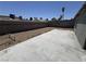 Empty backyard, enclosed by a block wall, with desert landscaping, and a concrete patio at 6723 Oak Valley Dr, Las Vegas, NV 89103