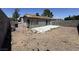 View of home's backyard with dirt, gravel, and debris needing extensive clean-up and landscaping at 6723 Oak Valley Dr, Las Vegas, NV 89103