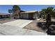Street view of a distressed single-story house with desert landscaping, a two-car garage, and significant damage needing repair at 6723 Oak Valley Dr, Las Vegas, NV 89103