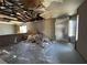 Interior view of damaged living room showing ceiling damage, peeling paint and missing drywall at 6723 Oak Valley Dr, Las Vegas, NV 89103