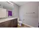 Bathroom featuring a granite countertop vanity, toilet, and a shower with a purple curtain at 6940 Crescent Gold St, North Las Vegas, NV 89086