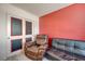Cozy bedroom with a leather chair and futon sofa, chalkboard closet doors, and a vibrant accent wall at 6940 Crescent Gold St, North Las Vegas, NV 89086