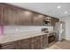 Well-lit kitchen featuring stainless steel appliances, brown cabinets, and granite countertops at 6940 Crescent Gold St, North Las Vegas, NV 89086
