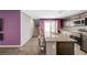 Modern kitchen with a large island, stainless steel appliances, and a view of the stairs at 6940 Crescent Gold St, North Las Vegas, NV 89086