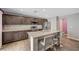 Spacious kitchen features a central island with granite countertops and sleek breakfast bar seating at 6940 Crescent Gold St, North Las Vegas, NV 89086