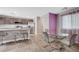Open-concept kitchen with stainless steel appliances, modern gray cabinets and dining area at 6940 Crescent Gold St, North Las Vegas, NV 89086