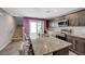 Modern kitchen with a large island, stainless steel appliances, and a door to the outside at 6940 Crescent Gold St, North Las Vegas, NV 89086
