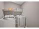 Laundry room featuring a white washer and dryer, and a storage shelf at 6940 Crescent Gold St, North Las Vegas, NV 89086