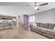 Open-concept living room with modern gray sofa, dining area and kitchen with stainless steel appliances at 6940 Crescent Gold St, North Las Vegas, NV 89086