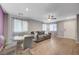 Open-concept living room with modern gray sofa, dining area and windows at 6940 Crescent Gold St, North Las Vegas, NV 89086