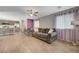 Open-concept living room with modern gray sofa, dining area and kitchen with stainless steel appliances at 6940 Crescent Gold St, North Las Vegas, NV 89086