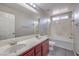 Bathroom featuring double sinks, bathtub with shower, and a large mirror at 7095 Mountain Den Ave, Las Vegas, NV 89179