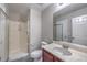 Bright bathroom features a glass-enclosed shower and a vanity with a marble countertop at 7095 Mountain Den Ave, Las Vegas, NV 89179