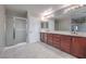 Bathroom with double vanity, large mirrors, and a separate glass-enclosed shower at 7095 Mountain Den Ave, Las Vegas, NV 89179