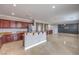 Open-concept kitchen with tiled floors, granite countertops, and dark wood cabinetry at 7095 Mountain Den Ave, Las Vegas, NV 89179
