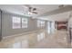 Large living room with travertine floors, many windows, and ceiling fan at 7095 Mountain Den Ave, Las Vegas, NV 89179