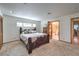 Bright bedroom with plush carpet, an inviting bed, and easy access to the ensuite bathroom at 7460 Buckskin Ave, Las Vegas, NV 89129