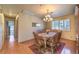 Cozy dining room with a chandelier and wood floors that seamlessly connects to other living spaces at 7460 Buckskin Ave, Las Vegas, NV 89129
