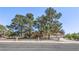 Charming home with mature trees, a well-kept lawn, and a classic wrought iron fence at 7460 Buckskin Ave, Las Vegas, NV 89129