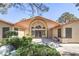 Inviting home featuring a grand entrance with a beautiful arched doorway and manicured landscaping at 7460 Buckskin Ave, Las Vegas, NV 89129