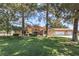 Inviting home with a lush green lawn, mature trees, and a spacious three-car garage at 7460 Buckskin Ave, Las Vegas, NV 89129