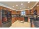 Modern kitchen featuring dark granite countertops, stainless appliances, and a view of the backyard at 7460 Buckskin Ave, Las Vegas, NV 89129