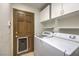 Laundry room with white washer and dryer, cabinets, and exterior door at 7460 Buckskin Ave, Las Vegas, NV 89129