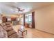 Open concept living room has laminate floors, a ceiling fan, and flows into the kitchen with breakfast bar seating at 7460 Buckskin Ave, Las Vegas, NV 89129