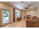 Living room features laminate flooring, a ceiling fan, a stone fireplace, and a large window to the backyard at 7460 Buckskin Ave, Las Vegas, NV 89129
