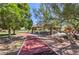 Community park featuring a covered picnic area, playground, and walking paths at 7460 Buckskin Ave, Las Vegas, NV 89129