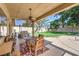 Inviting covered patio with ceiling fan overlooking lush backyard and barbecue at 7460 Buckskin Ave, Las Vegas, NV 89129