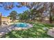 Sparkling backyard swimming pool with mature landscaping and lush lawn at 7460 Buckskin Ave, Las Vegas, NV 89129