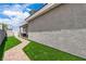 Backyard with green artificial grass with a brick walkway and stucco wall at 7738 Willow Cove Cir, Las Vegas, NV 89129