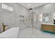 Bright bathroom with a modern tub, walk-in shower, and stylish vanity at 7738 Willow Cove Cir, Las Vegas, NV 89129