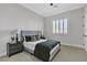 Bedroom featuring neutral gray walls, shuttered window, ceiling fan, carpet and neatly adorned bed and nightstands at 7738 Willow Cove Cir, Las Vegas, NV 89129