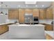 Modern kitchen with wood cabinets, stainless appliances, island, and marble floors at 7738 Willow Cove Cir, Las Vegas, NV 89129