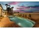 Backyard pool with spa and exterior lighting, palm trees and a colorful sky at 7738 Willow Cove Cir, Las Vegas, NV 89129