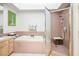 Bright bathroom featuring a soaking tub, separate shower, and a light wood vanity with ample counter space at 8236 Round Hills Cir, Las Vegas, NV 89113