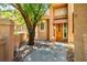 Warm home entrance featuring a wooden door, lush greenery, and stone accents at 8236 Round Hills Cir, Las Vegas, NV 89113