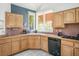 Functional kitchen with wooden cabinets, black appliances, and a bright window over the sink at 8236 Round Hills Cir, Las Vegas, NV 89113