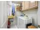 Functional laundry room with a washer, dryer, and upper cabinets for storage at 8236 Round Hills Cir, Las Vegas, NV 89113