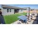 Large backyard featuring lush artificial grass, outdoor seating, and a covered patio at 832 Canonbury St, Henderson, NV 89011