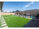 Expansive backyard featuring artificial turf, a large patio area, and an outdoor dining set at 832 Canonbury St, Henderson, NV 89011
